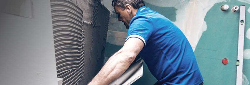 Flislegging av bad. Våtromsplater og rørkoblinger i bakgrunnen.