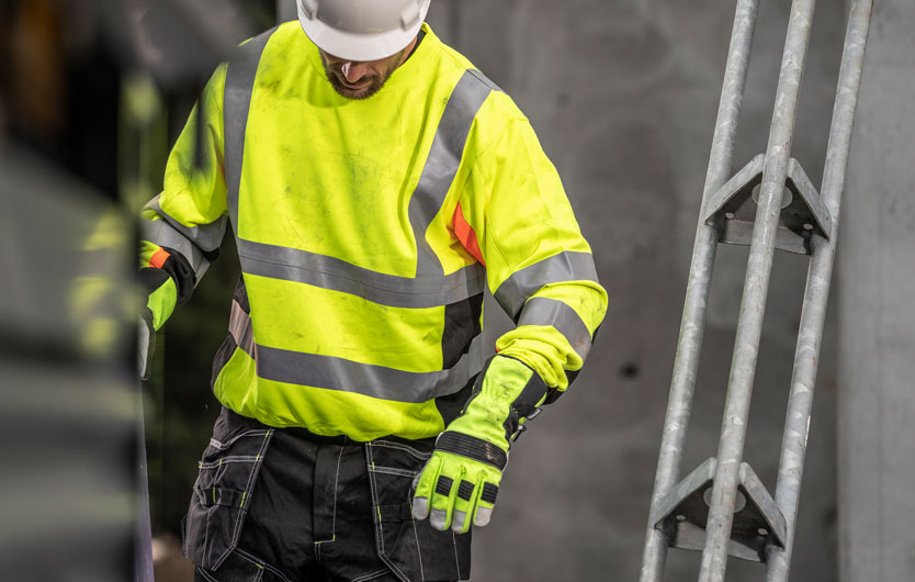 Byggarbeider iført hjelm og fluoriserende genser